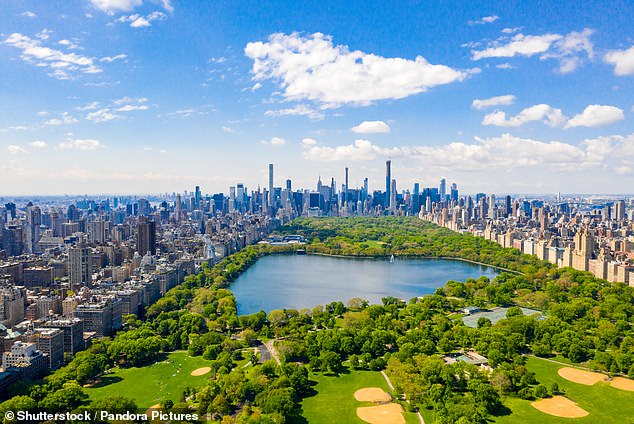 An aerial view shows Central Park, an 843-acre public park in the heart of Manhattan.  It is surrounded by dense housing and commercial buildings.