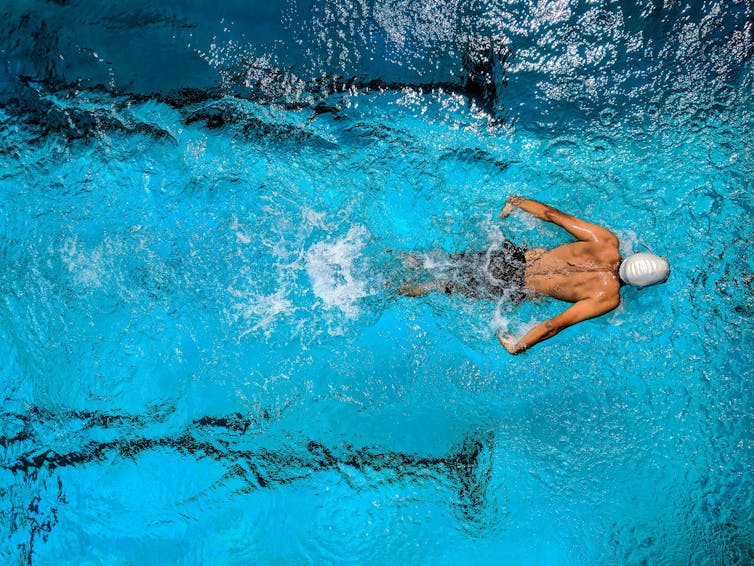 Bird's eye view of a man swimming in a pool.