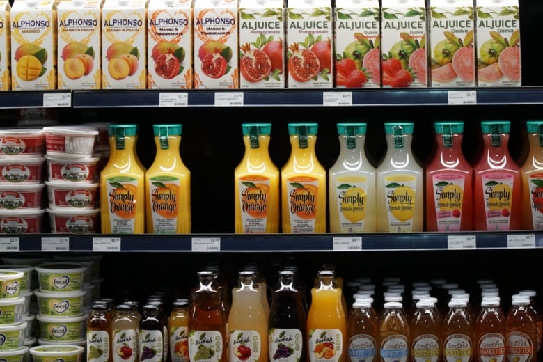 A refrigerator shelf in a grocery store, containing different brands of Canadian fruit juices.