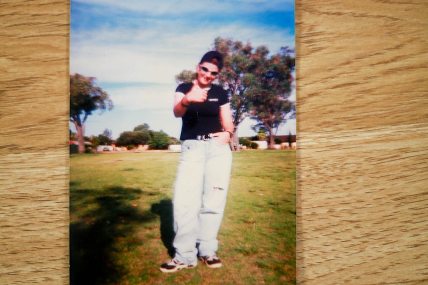 Polaroid of a teenage girl showing a thumbs up. 