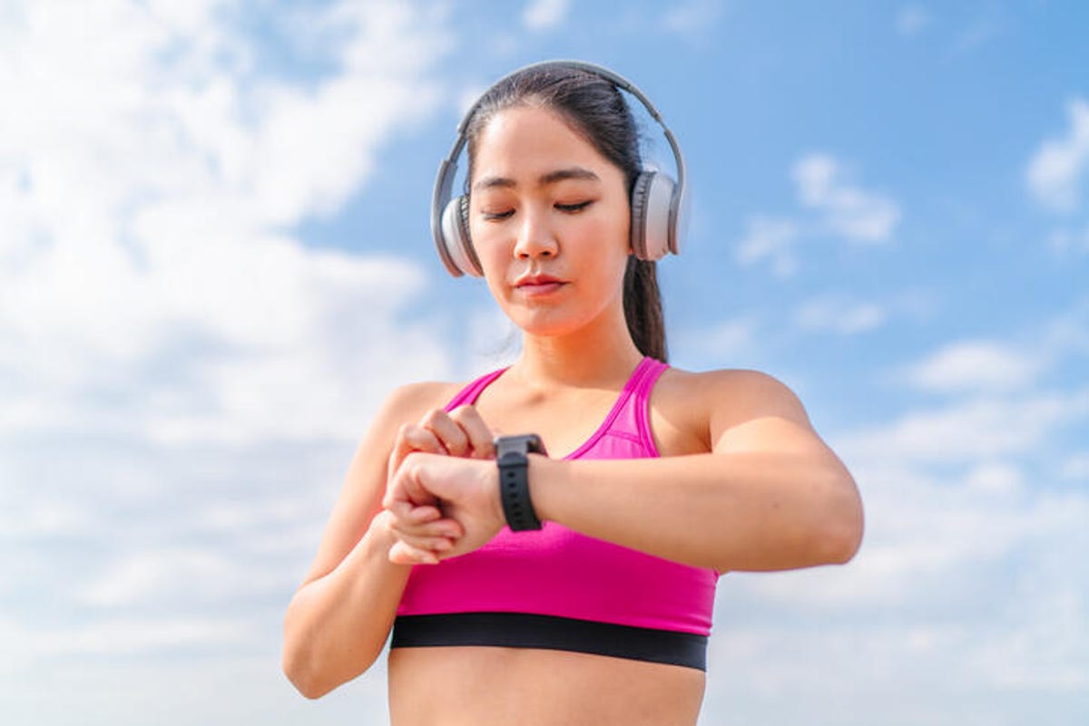 Woman tracking a workout outdoors with a fitness tracker.