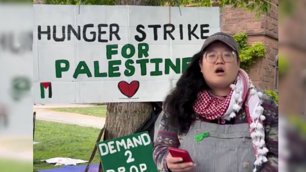 protester in front of hunger strike sign