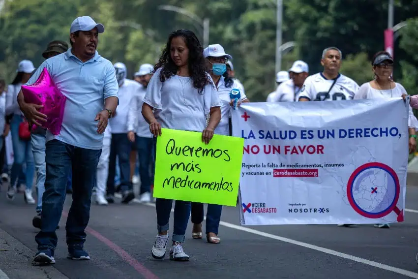 Protesters hold signs demanding medicine